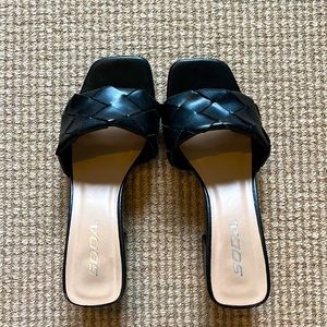 Low heel black shoes with patterns.